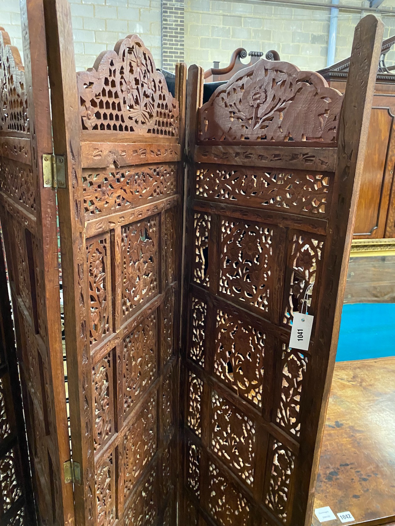 An Indian carved hardwood four fold screen, each panel width 51cm, height 183cm